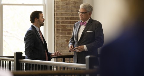 Man handing a paper to a colleague